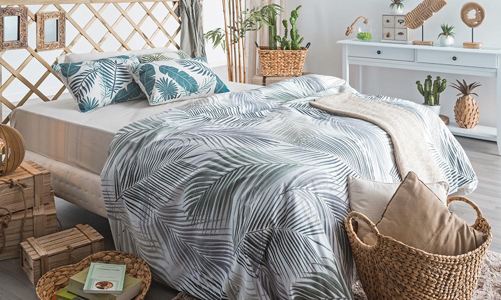 Si no quieres arriesgar a usar papel pintado o vinilos en la pared, puedes optar por textiles con estampado tropical. decoracion apartamento playa