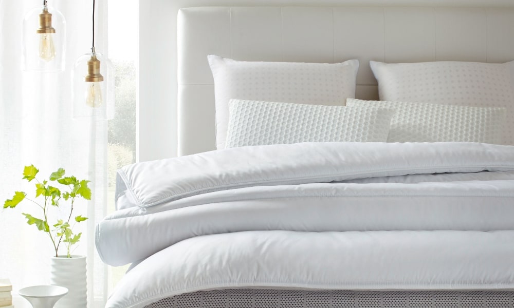 como lavar almohadas de cama con cojines y edredón blancos 