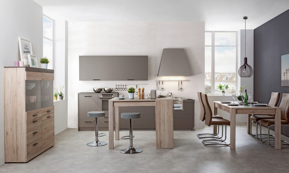 Si la cocina es cuadrada o, aunque sea pequeña, es amplia y no puedes alargar la encimera, puedes pensar en colocar una mesa alta con almacenaje en lugar de una barra como tal cocina pequeña con barra